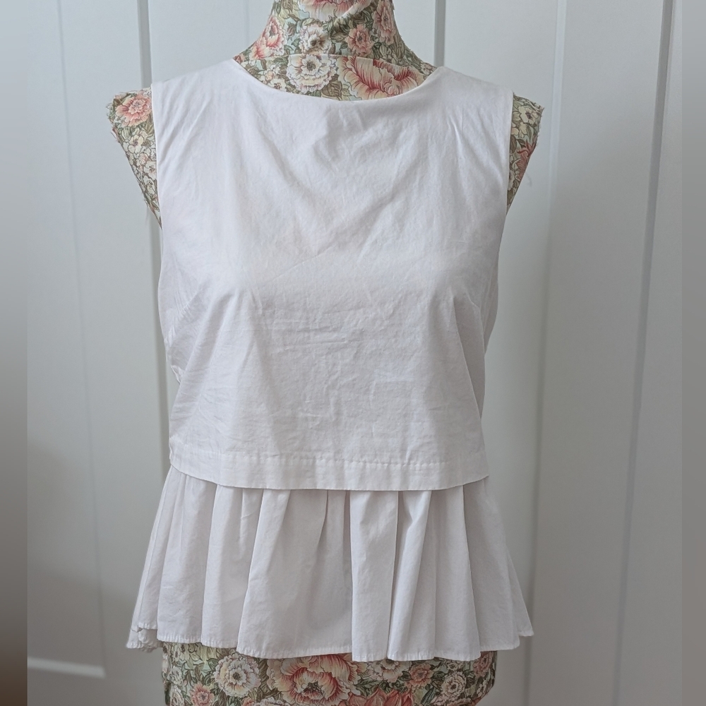 Sleeveless white cotton peplum top